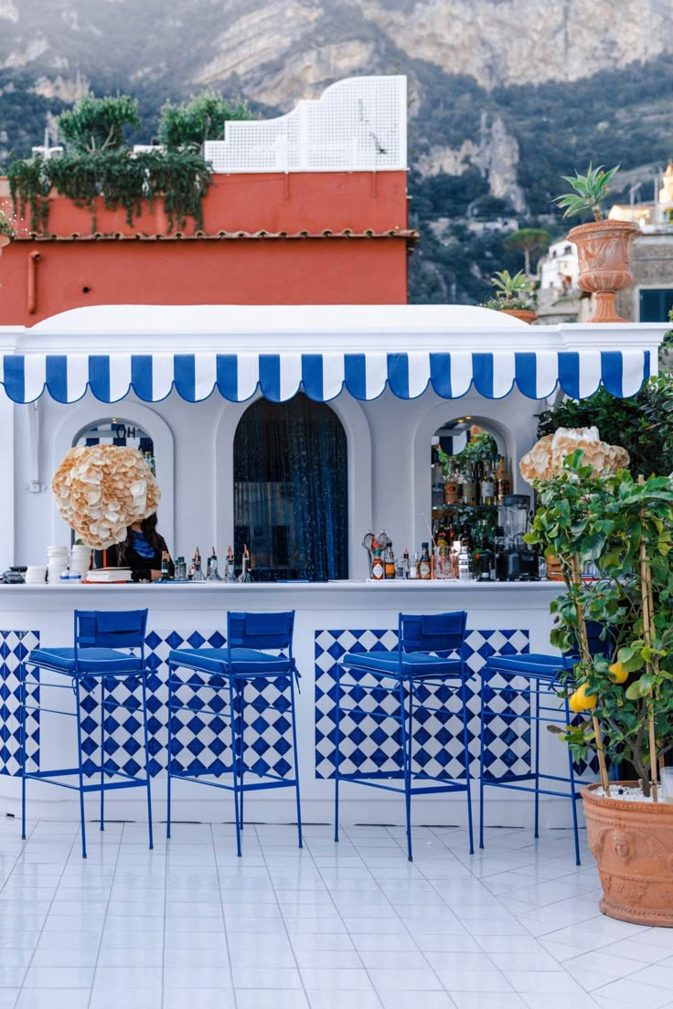 an outdoor bar with blue and white chairs