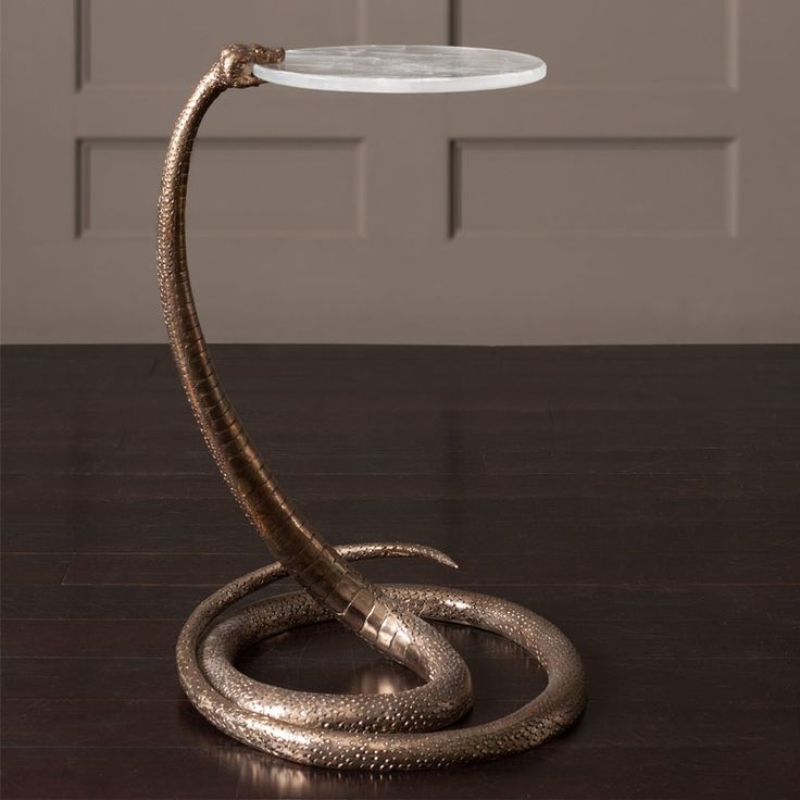 a table lamp with a snake on it's side and a glass plate on top