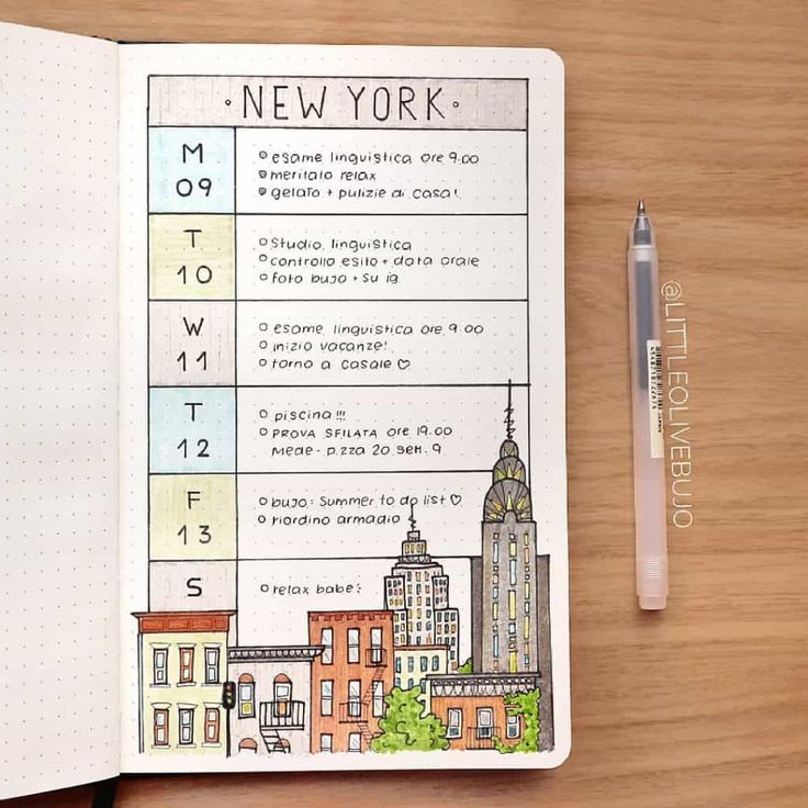 an open notebook with the new york city guide on it and a pen next to it