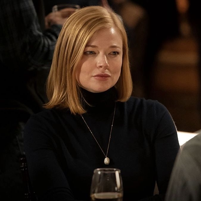 a woman sitting at a table with a glass of wine