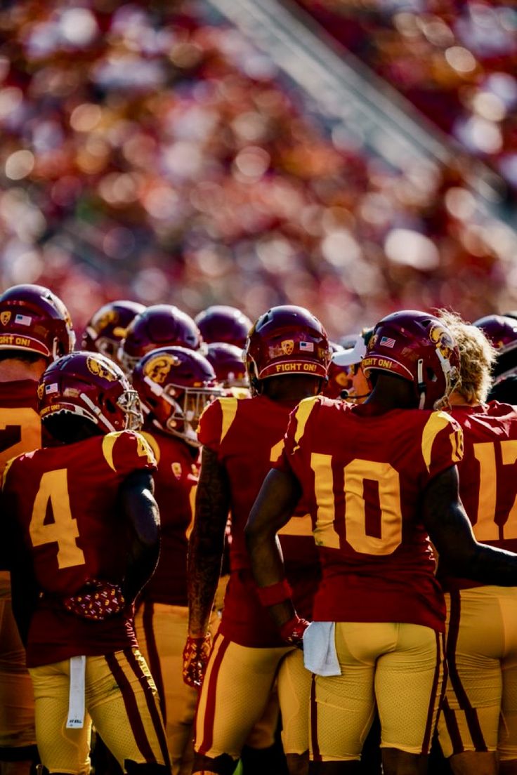 a group of football players standing on top of a field next to each other in uniform