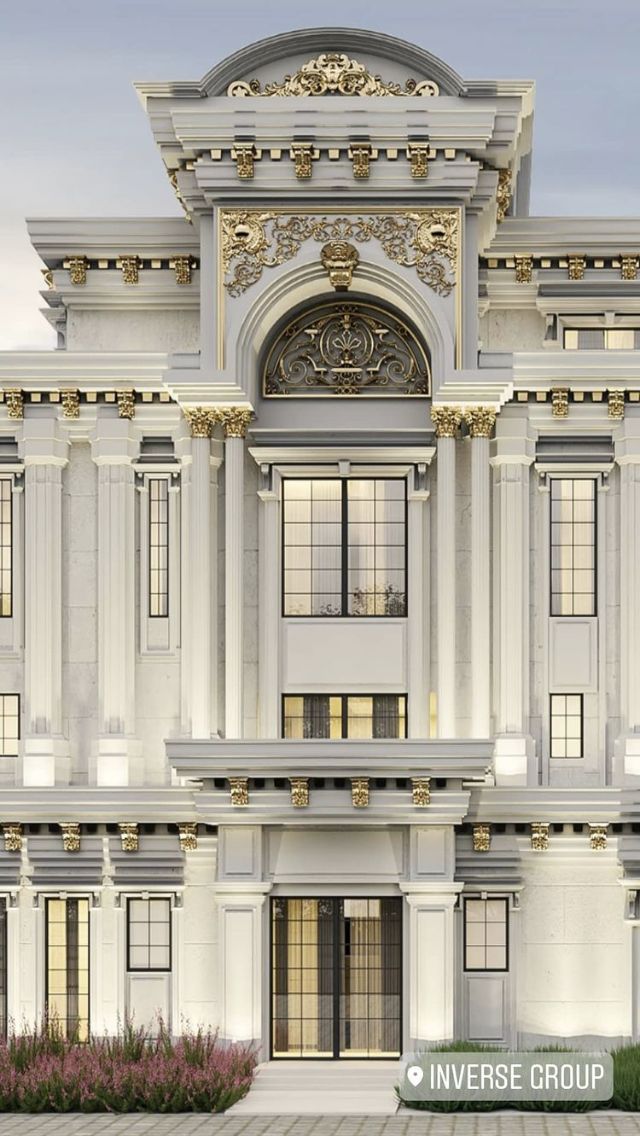 a large white building with many windows and gold trimmings on the top floor