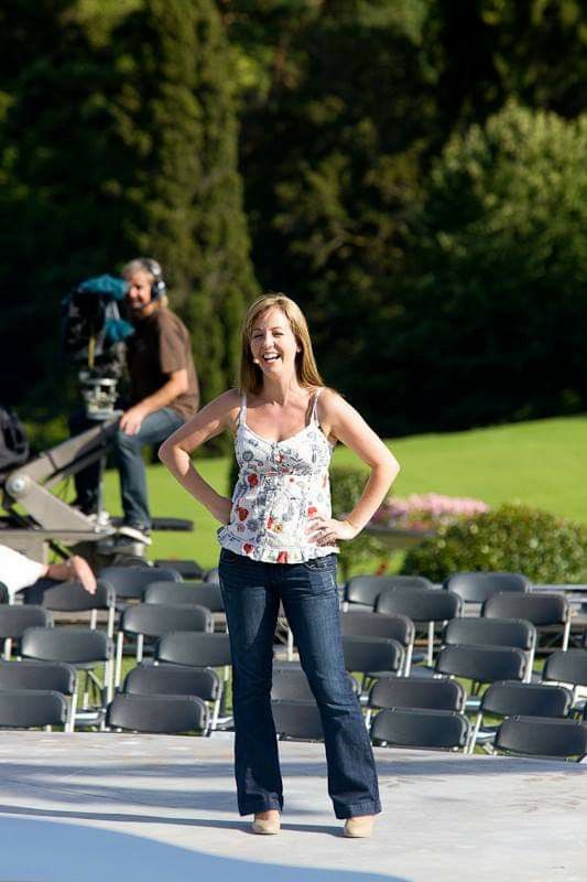 a woman standing next to a man in front of empty chairs