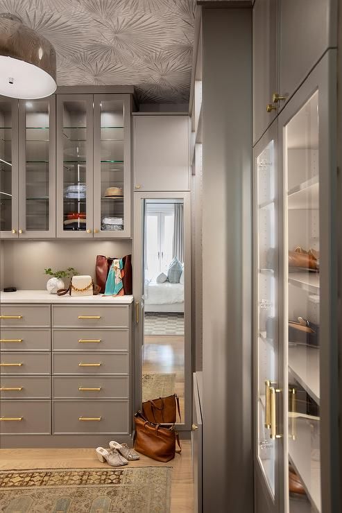 the interior of a kitchen with metallic cabinets and gold trim on the doors, along with an area rug