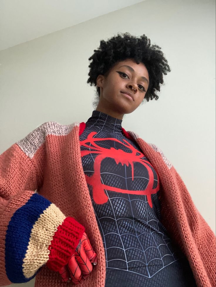 a woman wearing a spiderman sweater and gloves