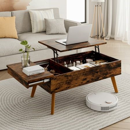 a living room with a couch, coffee table and laptop on top of the coffee table