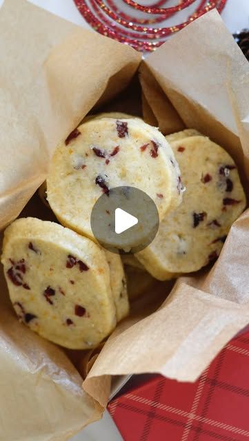 some food is in a paper bag on a table with red and white napkins