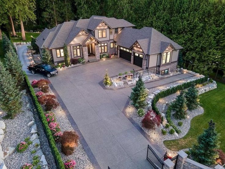 an aerial view of a large home with driveway and landscaping at night, taken from above