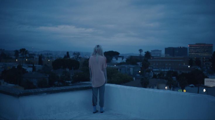 a woman standing on top of a roof at night