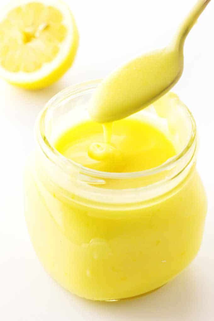 a spoon in a jar filled with lemon custard