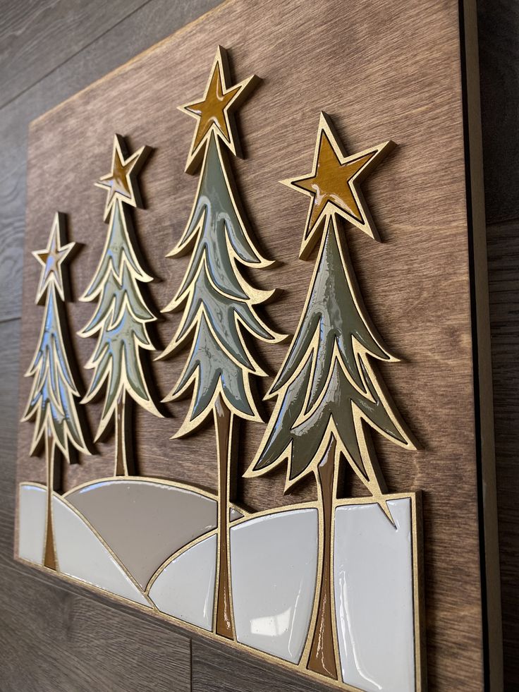 a wooden wall hanging with christmas trees on it