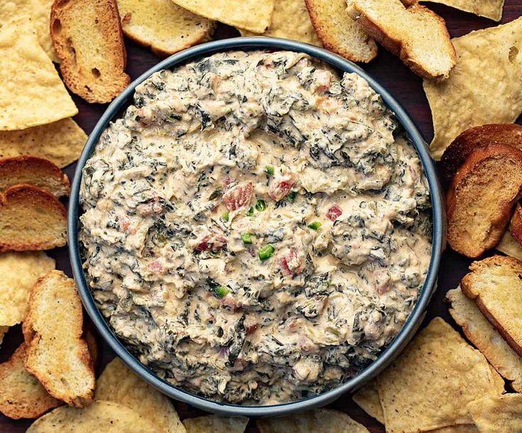 a bowl filled with dip surrounded by chips