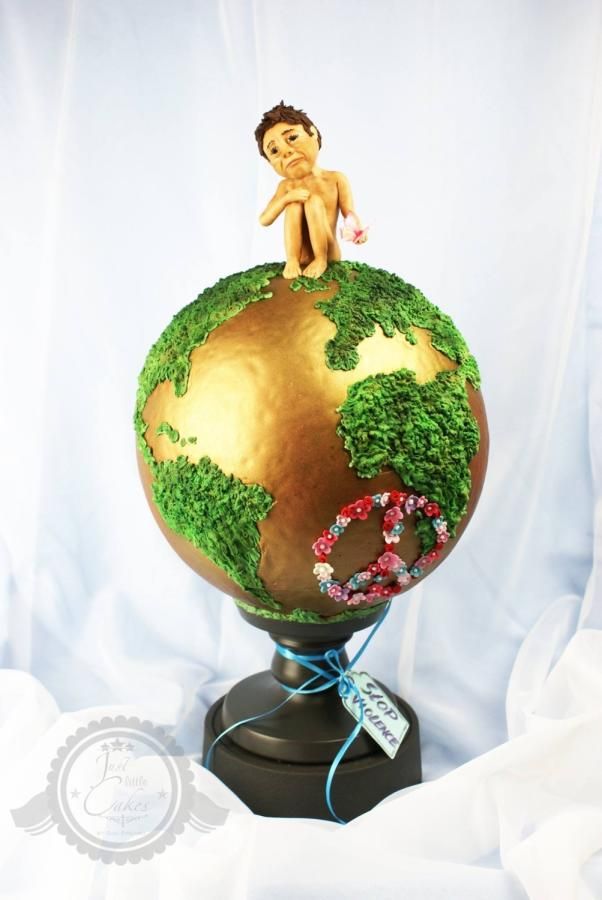 a small globe with grass growing on it and a person sitting on top of it