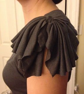 the back of a woman's dress with ruffles on it and her hair in a bun