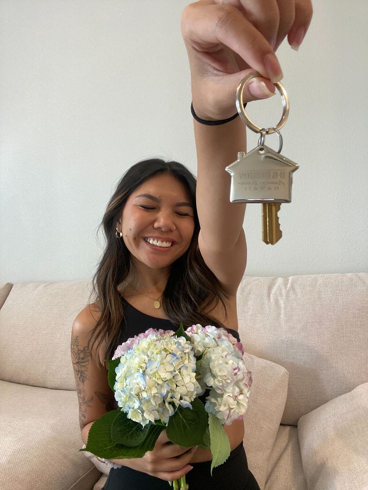 a woman holding a bunch of flowers and a key