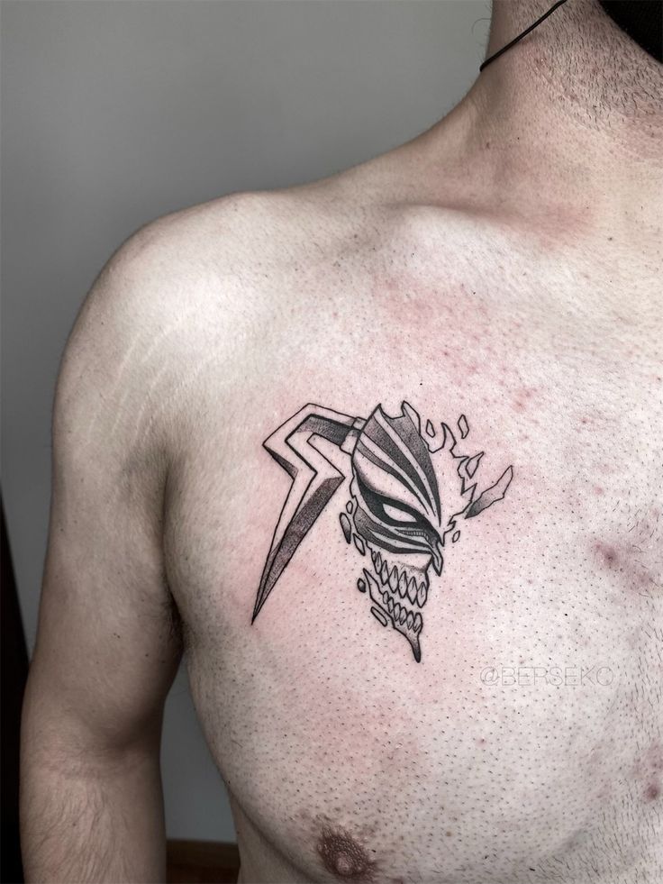 a man with a tattoo on his chest has a knife and skull in the middle