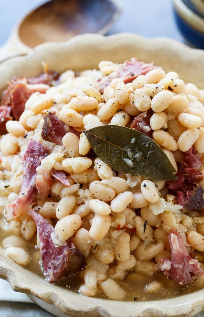 a bowl filled with beans and meat on top of a table