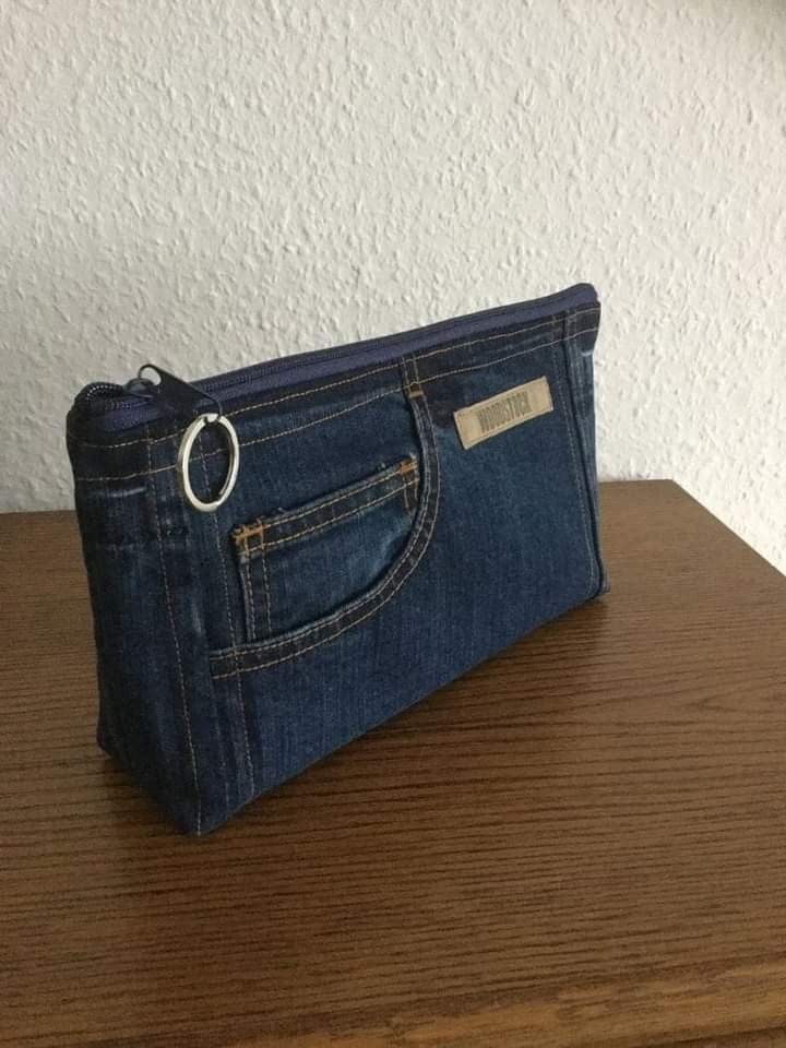 a denim purse sitting on top of a wooden table