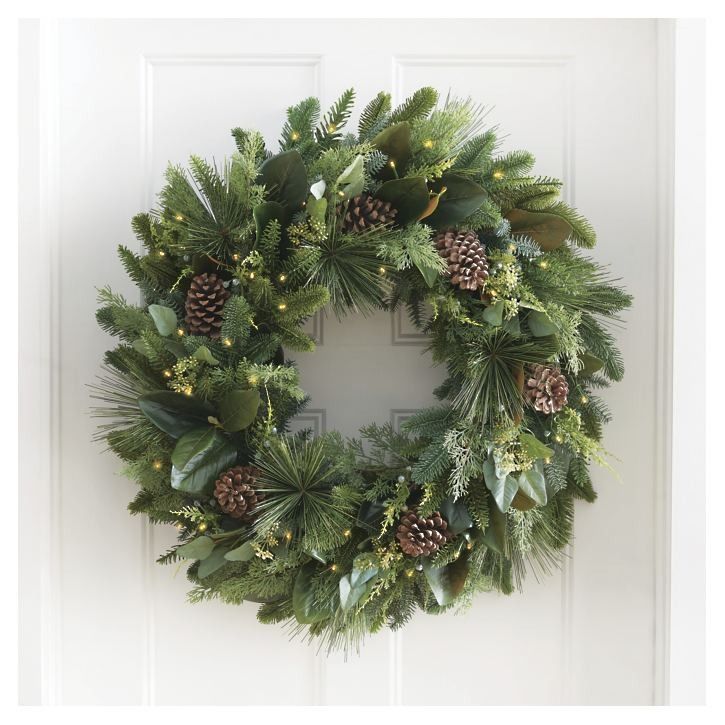 a christmas wreath with pine cones and greenery