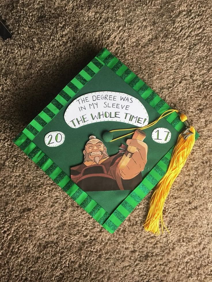 a green and yellow graduation cap with an image of a cartoon character on it