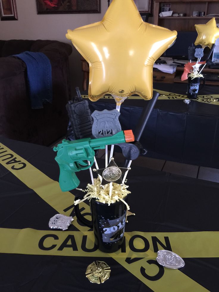 a table topped with balloons and star shaped items on top of a black table cloth