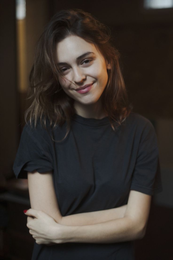 a woman with her arms crossed sitting at a table