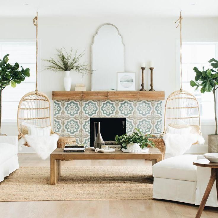 a living room filled with furniture and a fire place in front of a wall mounted mirror