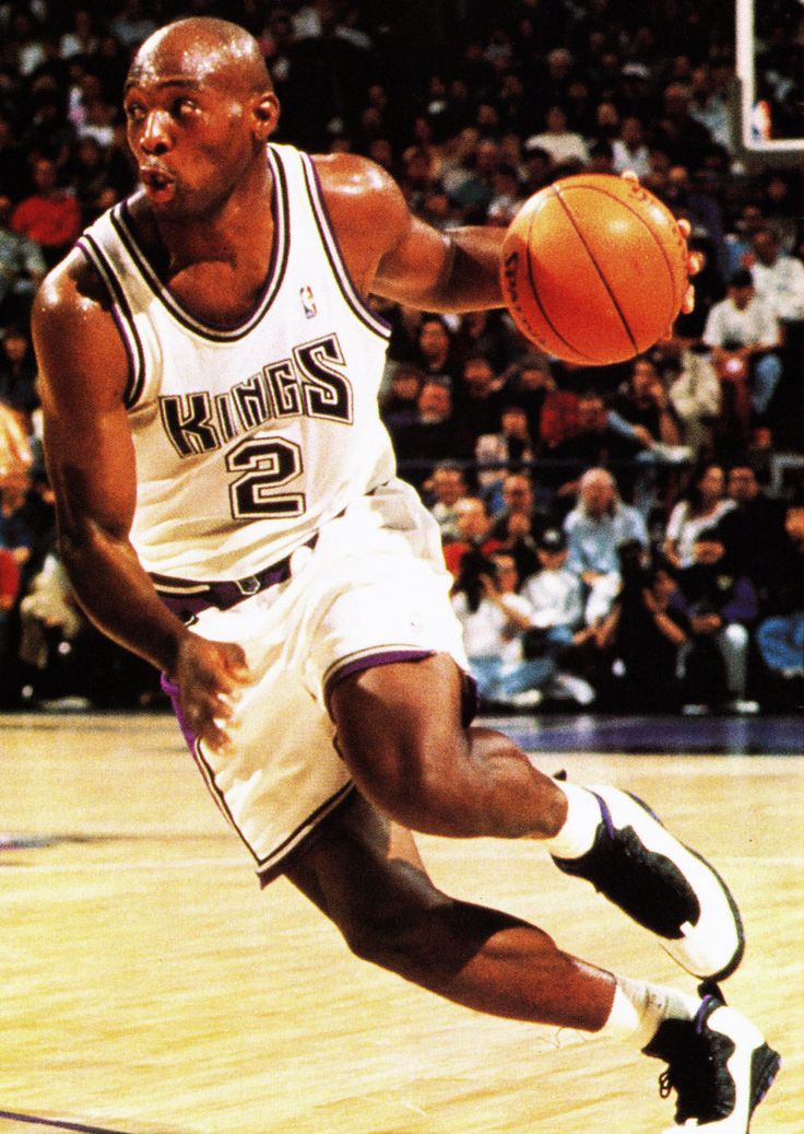 a basketball player is running with the ball in his hand while people watch from the stands