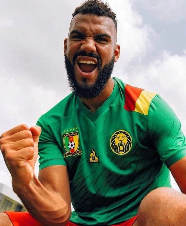 a man sitting on the ground with his fist up and mouth wide open in celebration