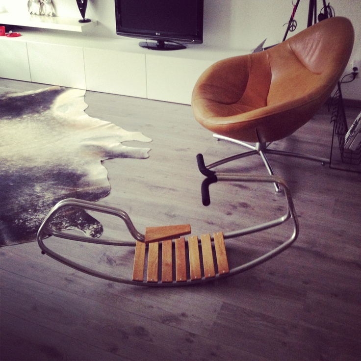 a chair and ottoman sitting on the floor in front of a flat screen tv,