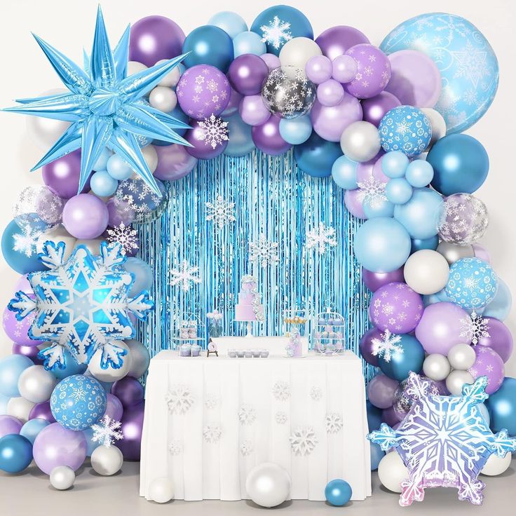 a blue and purple balloon arch with snowflakes, stars, and balloons