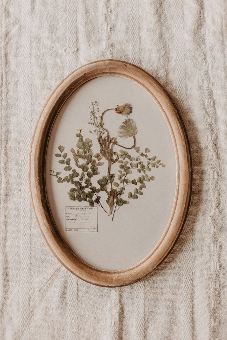 a close up of a embroidery on a table cloth with leaves and flowers in it