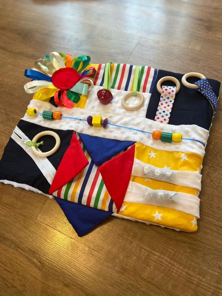 an assortment of toys laid out on a wooden floor in the shape of a quilt