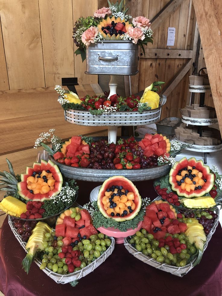 a table topped with lots of different types of fruits and veggies on trays