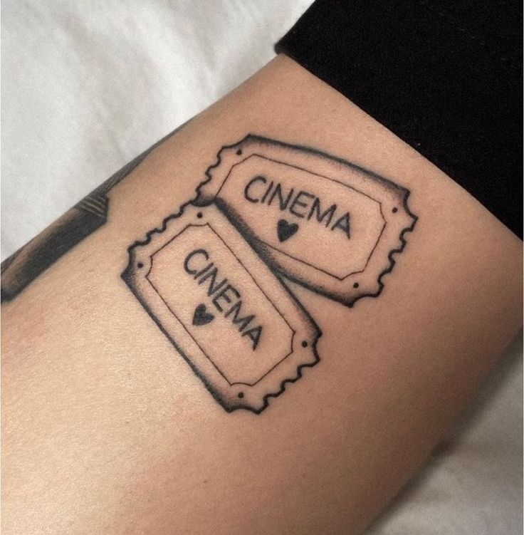 a woman's thigh with two tickets on it and the words cinema written in black ink