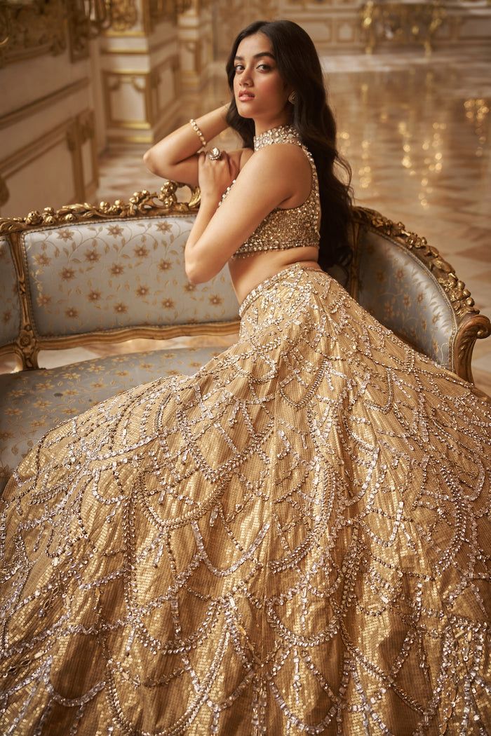 This lehenga set features crystal embroidery in chandelier inspired pattern on an antique gold sequin base. The matching blouse and dupatta have crystal drops.From Seema Gujral's Inara collection. DELIVERY TIMEPlease allow 8-12 weeks for your outfit to arrive. FABRIC DETAILSNet Professional cleaning only. Golden Lehenga Aesthetic, Lehenga Sparkly, Trendy Dress Designs, Lehenga Fits, Gold Lengha, Aesthetic Eid, Golden Lehenga, Lehenga Bridesmaid, Chic Prom Dresses