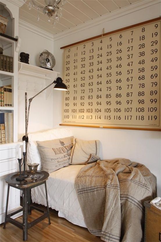 a room with a bed, lamp and bookshelf on the wall above it