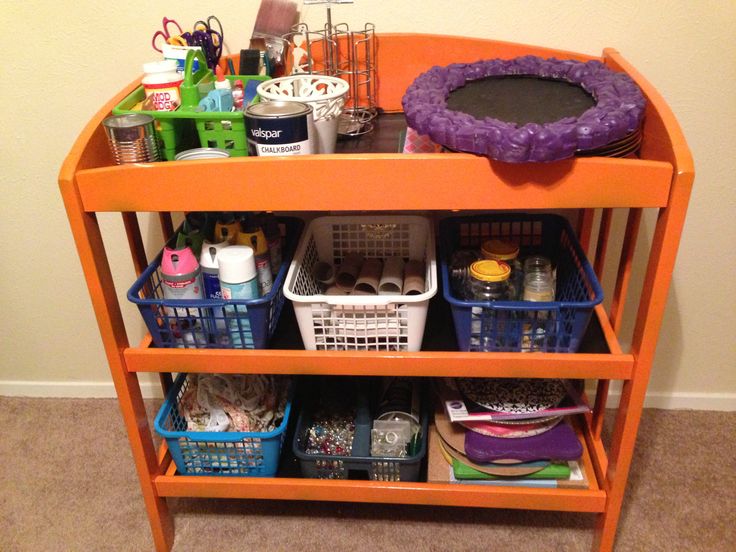 an orange shelf filled with lots of toys and other items on top of carpeted floor