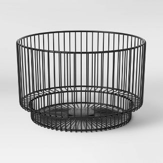 a black wire basket sitting on top of a table