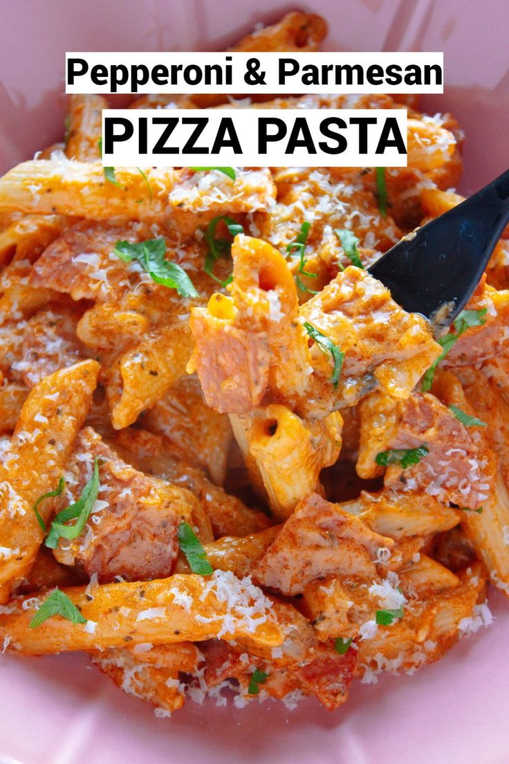 a pink bowl filled with pasta covered in sauce and parmesan cheese