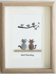 two cats are sitting on a shelf under a framed art print that says bird watching