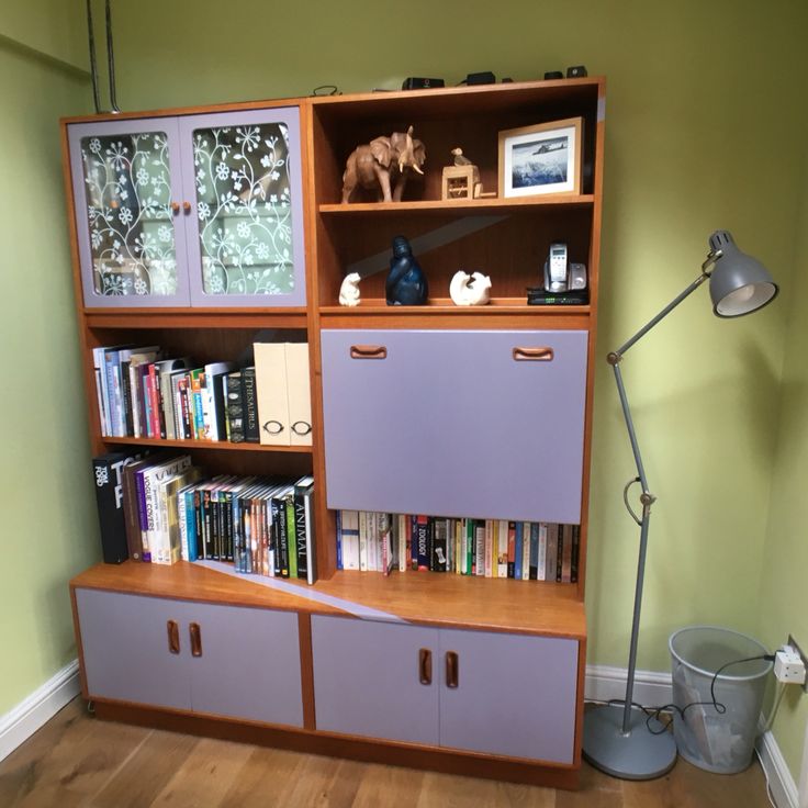 a bookshelf filled with lots of books next to a lamp