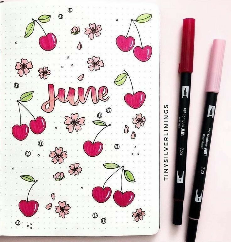 an open notebook with the word june written on it next to two markers and a pen