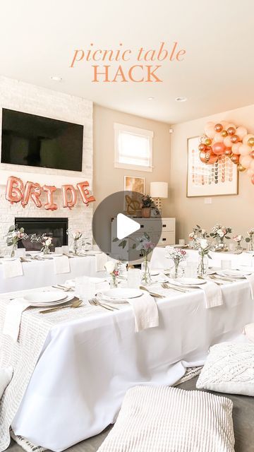 a table set up for a wedding reception with white linens and flowers on it