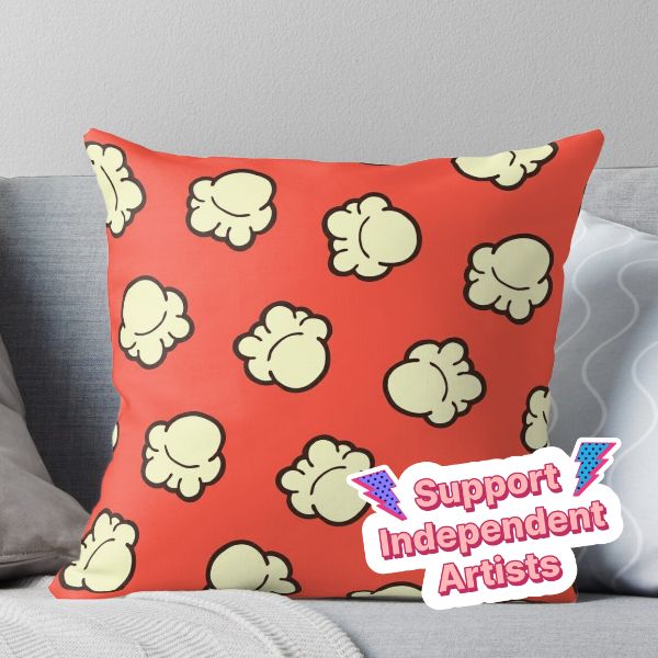 a red pillow sitting on top of a couch next to a white pillow with the words support independent artists