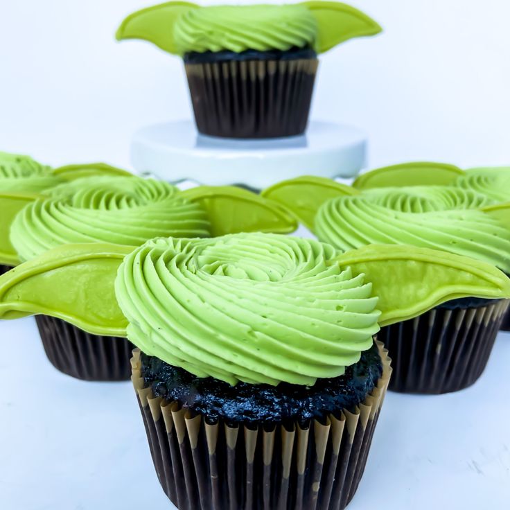 some cupcakes with green frosting on them are arranged in the shape of a flower