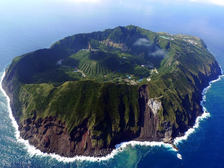 an island in the middle of the ocean with lots of land on top of it