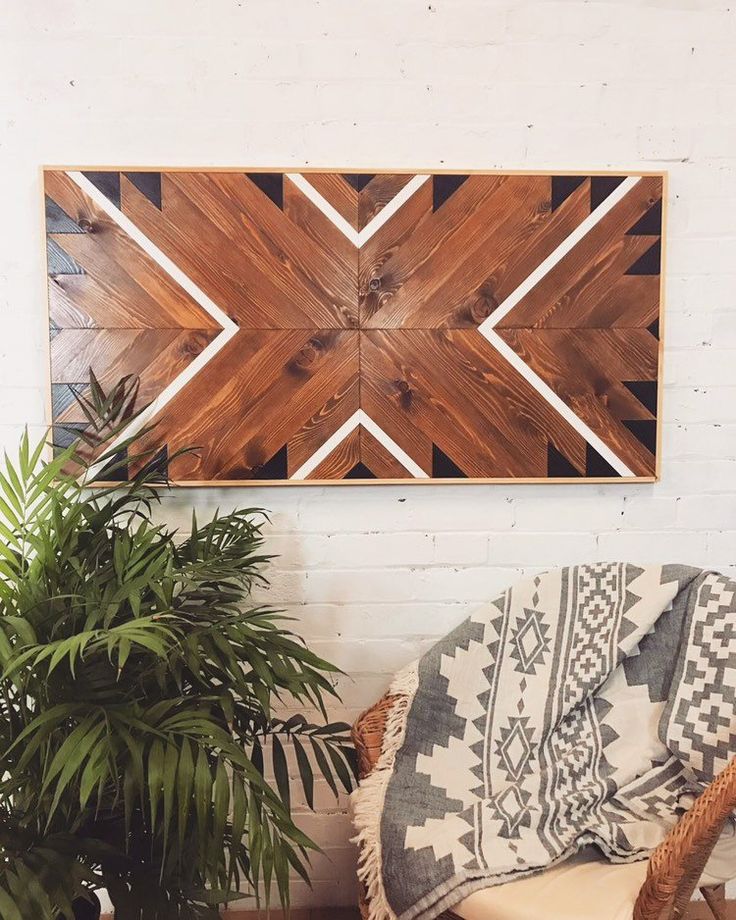 a wooden wall hanging over a couch next to a potted plant and a rug