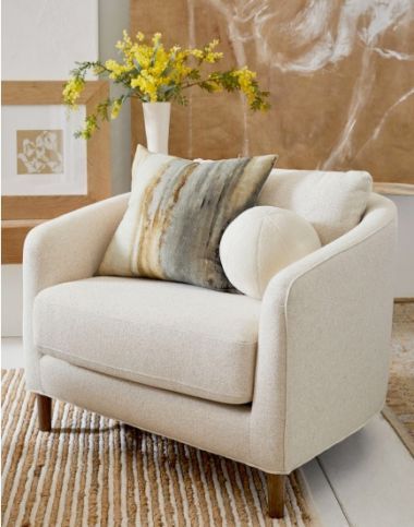 a white chair sitting in front of a vase with yellow flowers on top of it