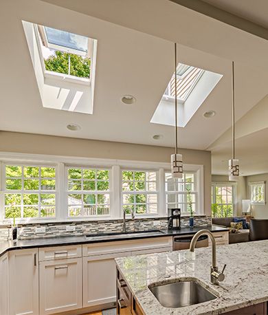 a kitchen with an island and skylights in it